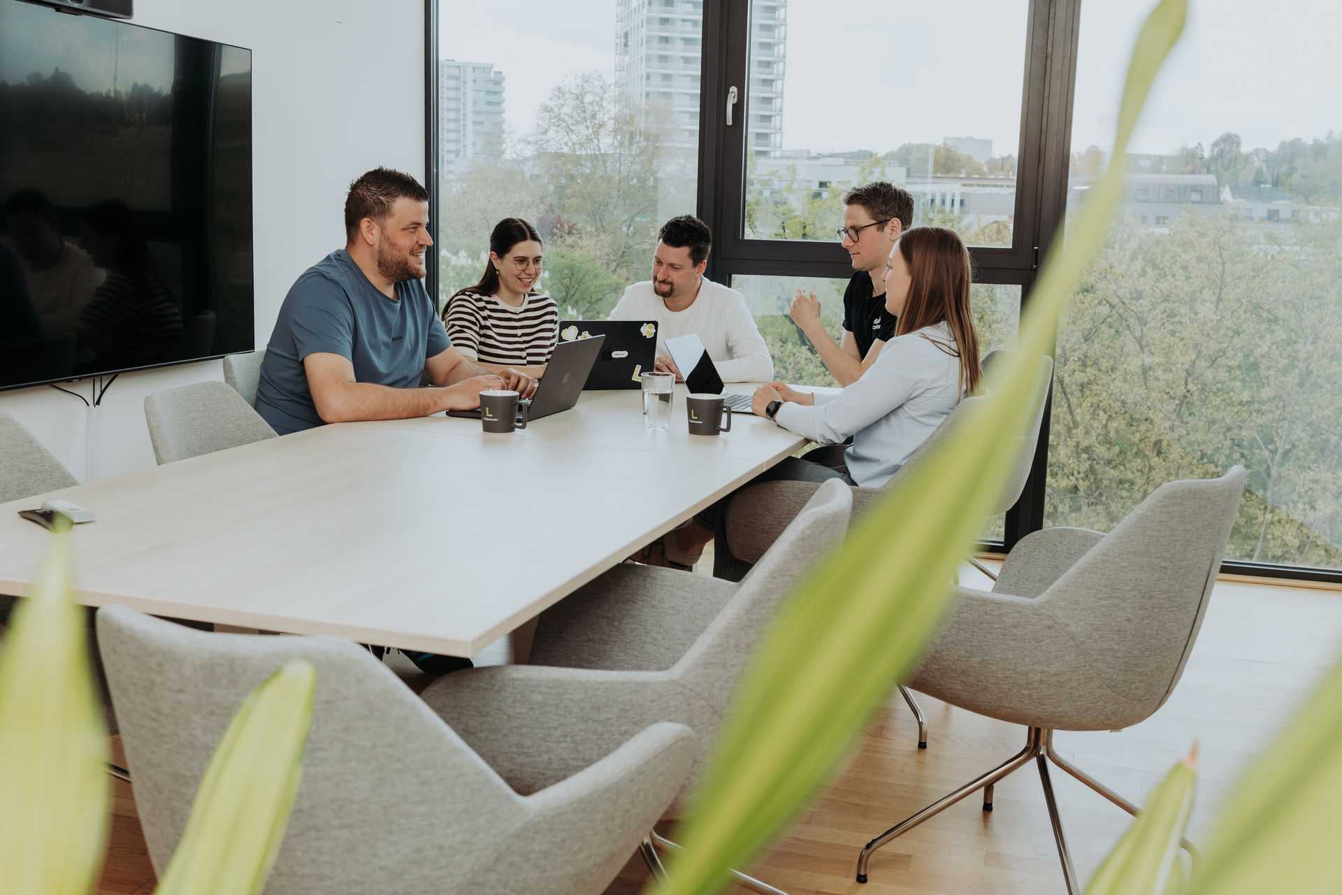 Teammeeting mit 4 Personen an einem Tisch
